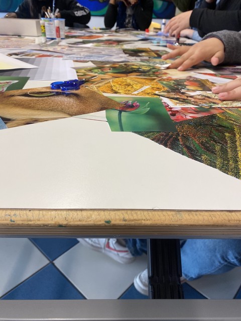 Tavolo di lavoro per un laboratorio di collage, con ritagli e forbici