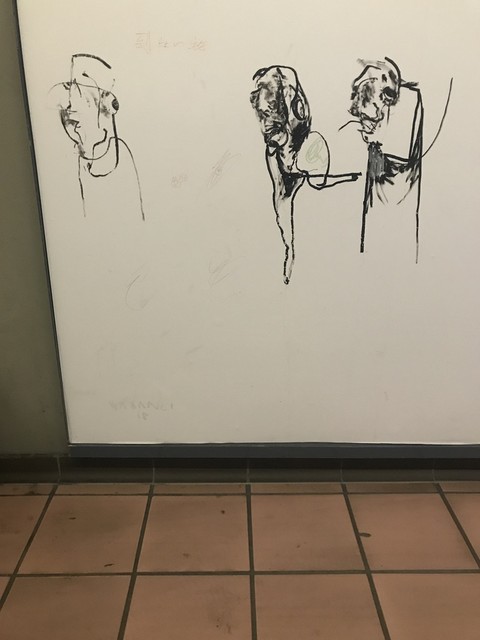 Disegni a inchiostro di figure su una lavagna bianca